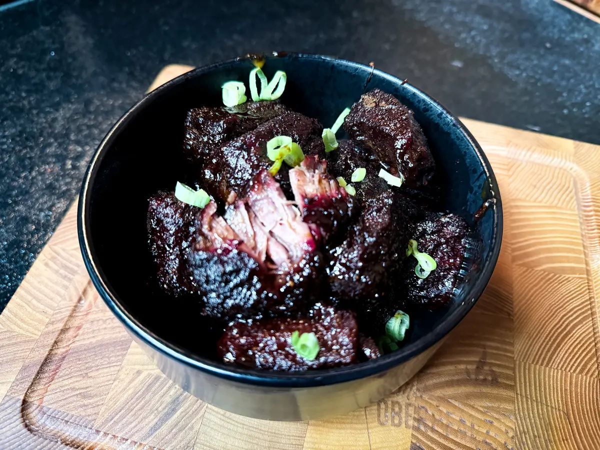 Glasierte Chuck Roast Burnt Ends mit Frühlingszwiebeln in der Schale