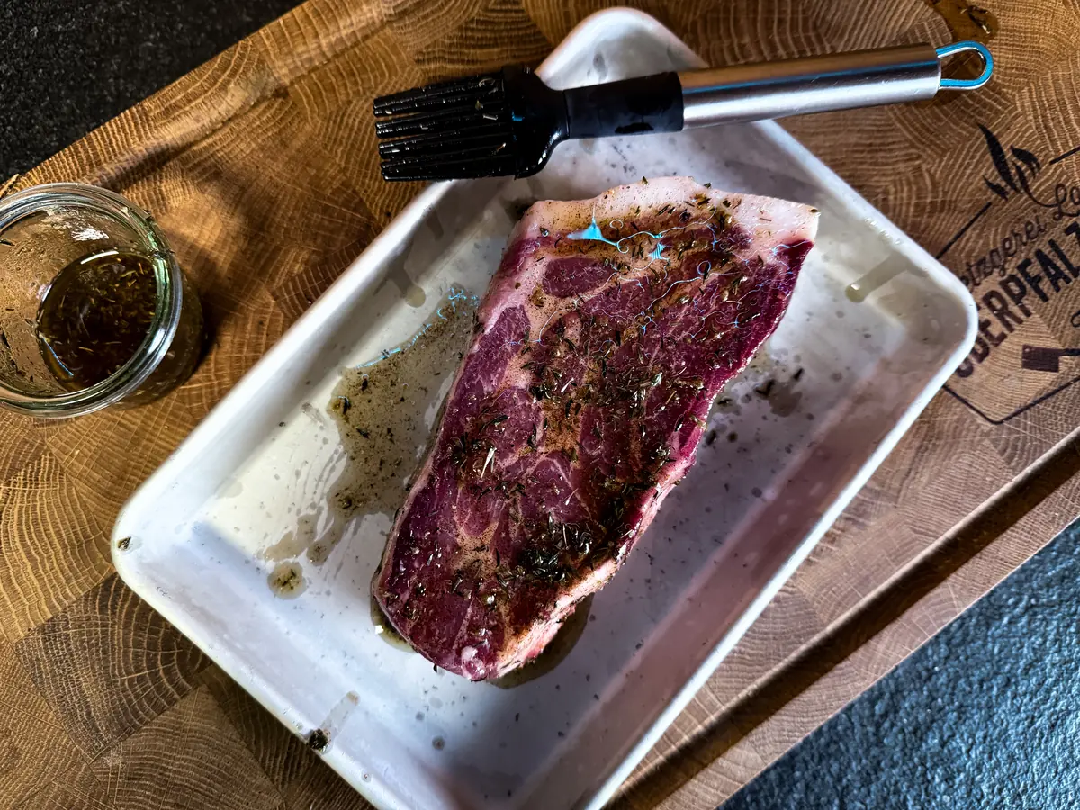 Mariniertes Dry Aged Kotelettsteak mit Pinsel in der Schale