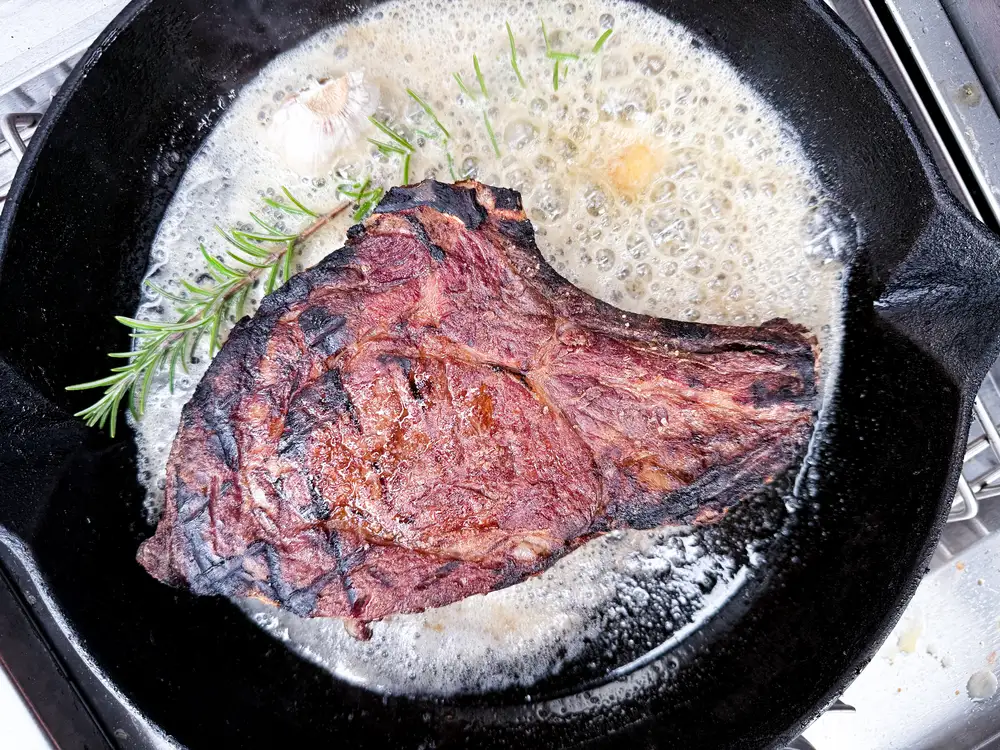 Gegrilltes Entrecôte mit Butter und Rosmarin in der Gusspfanne