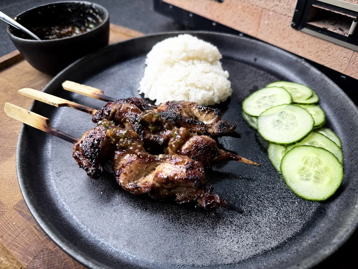 Gai Ping Thai-Hähnchenspieße mit Klebreis und Gurke auf dem Teller