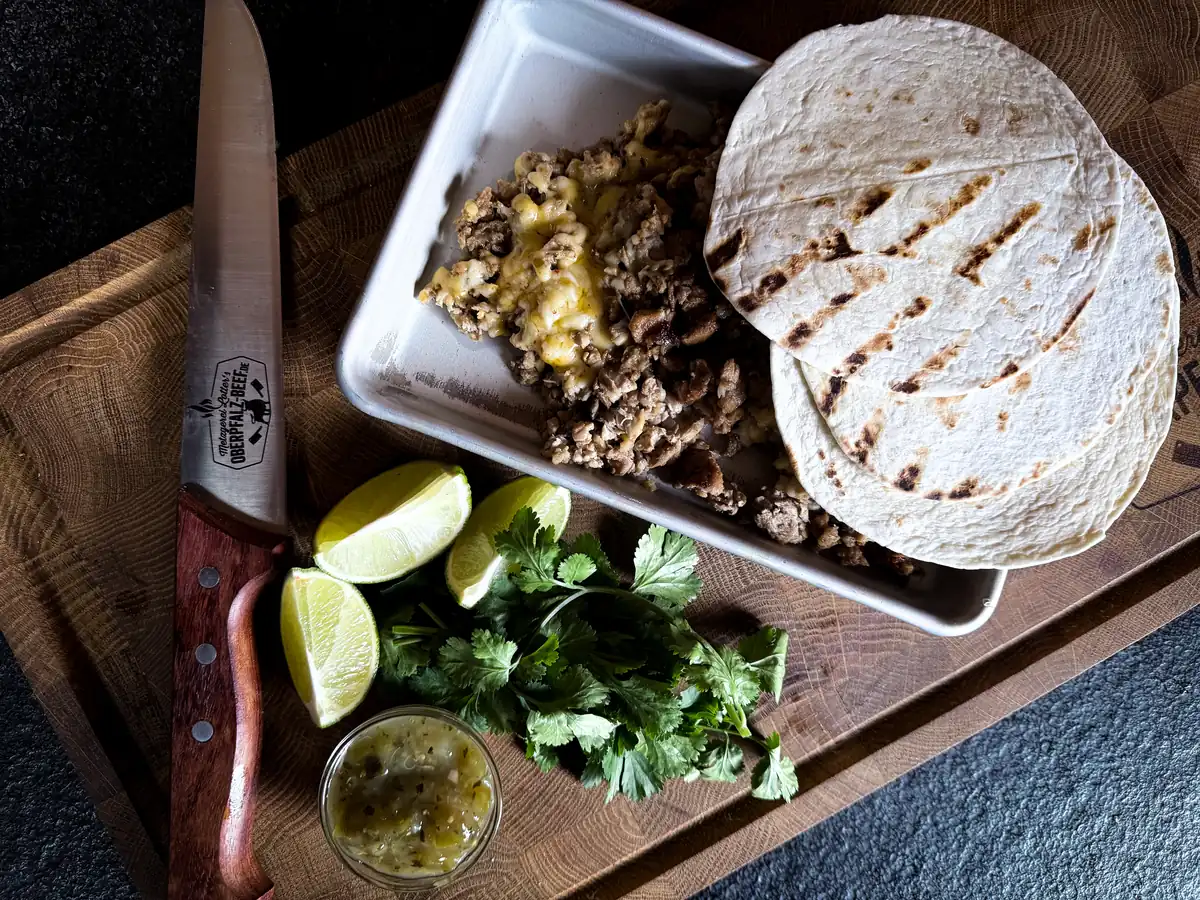 Kachelfleisch-Tacos mit gegrillten Tortillas, Limetten, Koriander und Salsa