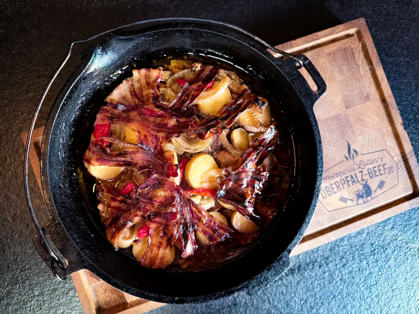 Fertiges Schichtfleisch mit knusprigem Bacon im Dutch Oven
