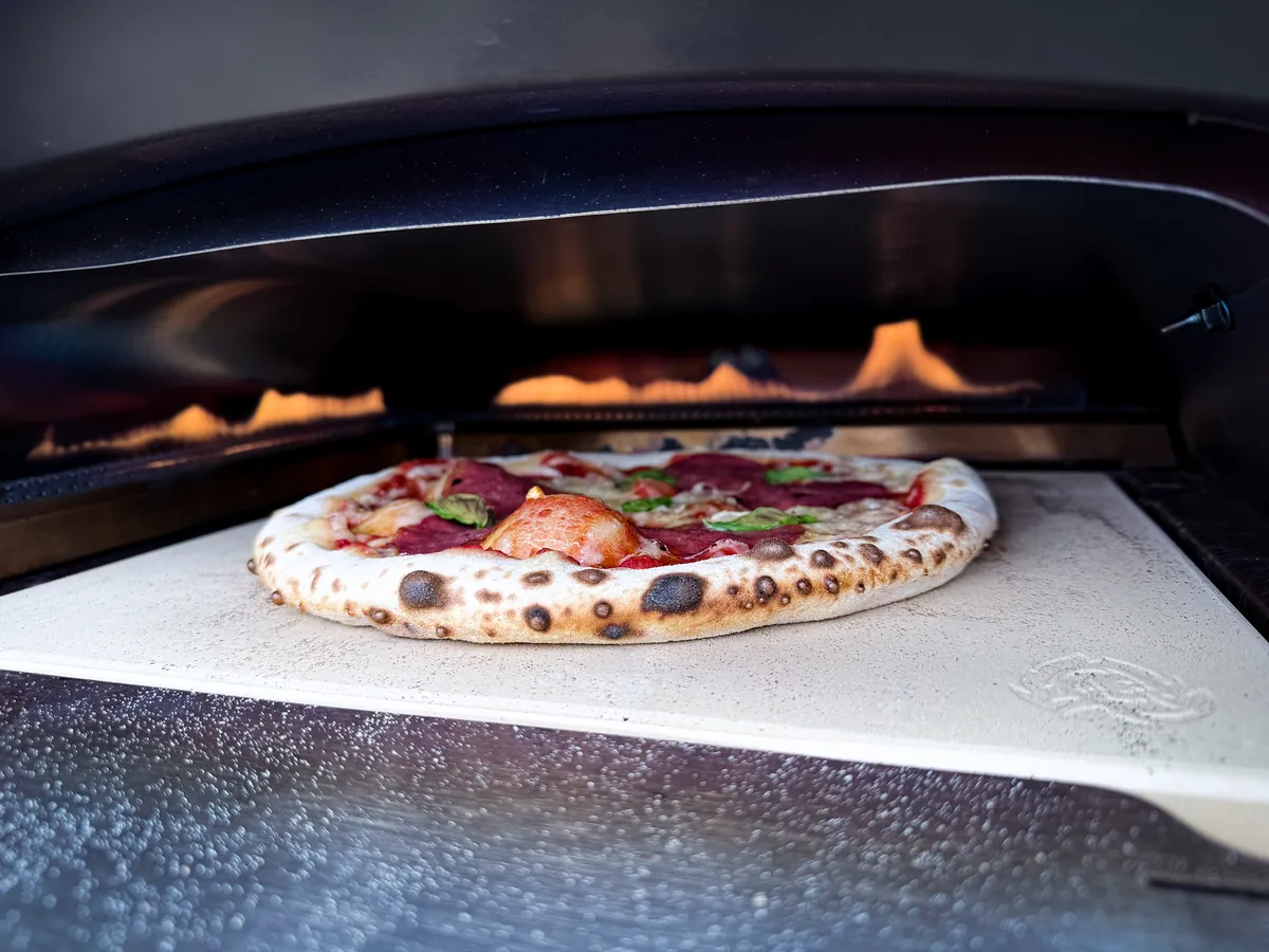 Trüffel-Salami-Pizza im Gas-Pizzaofen auf dem Pizzastein