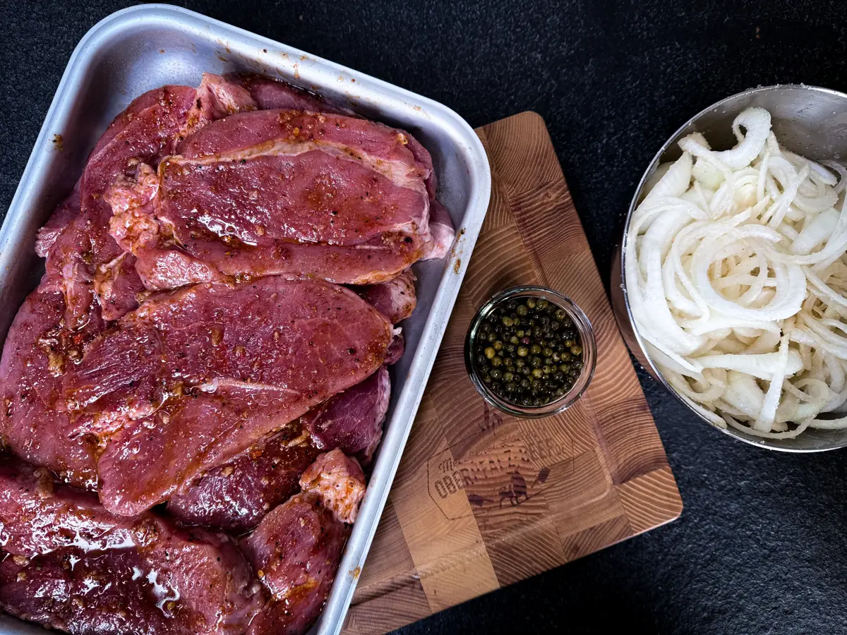 Gewürzte Schweinenackenscheiben und Zwiebelringe
