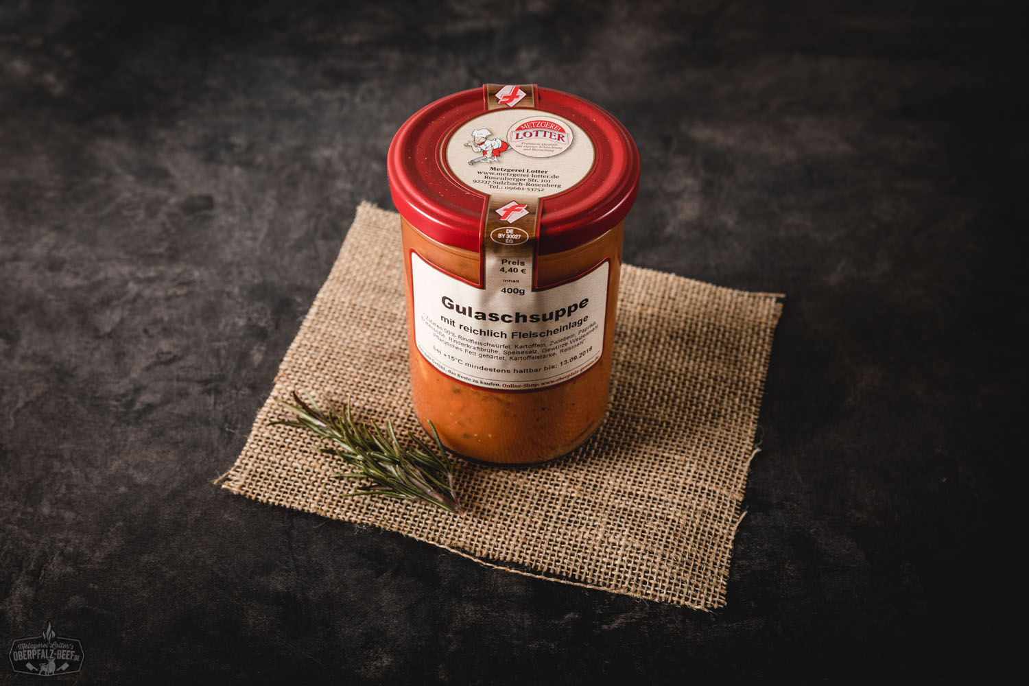 Hausgemachte Gulaschsuppe im Glas – Fertiggericht aus hochwertigem Rindfleisch Hausgemachte Gulaschsuppe im Einmachglas, angerichtet auf einem Holzbrett mit frischen Zutaten wie Paprika, Zwiebeln und Kräutern – herzhafte Fleischsuppe nach traditionellem Rezept, ideal für den Vorrat oder das schnelle Mittagessen.