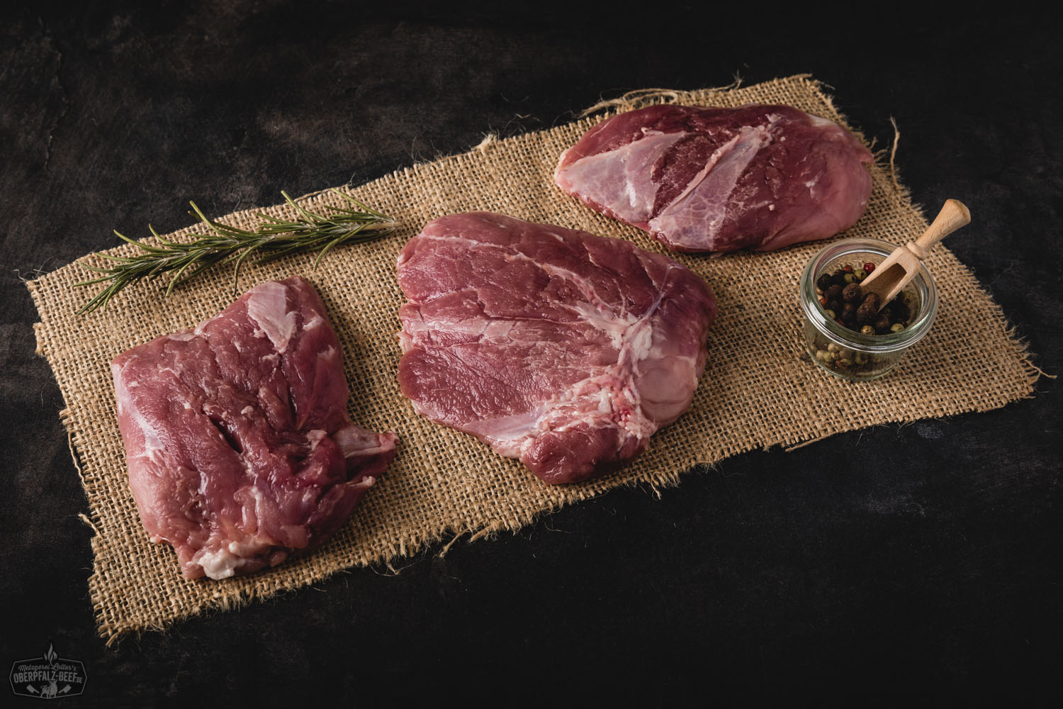 Ein saftiger und zarter Cuscino-Schnitt vom Oberpfälzer Landschwein, präsentiert auf einem dunklen Hintergrund, ideal für authentische bayerische Fleischgerichte.