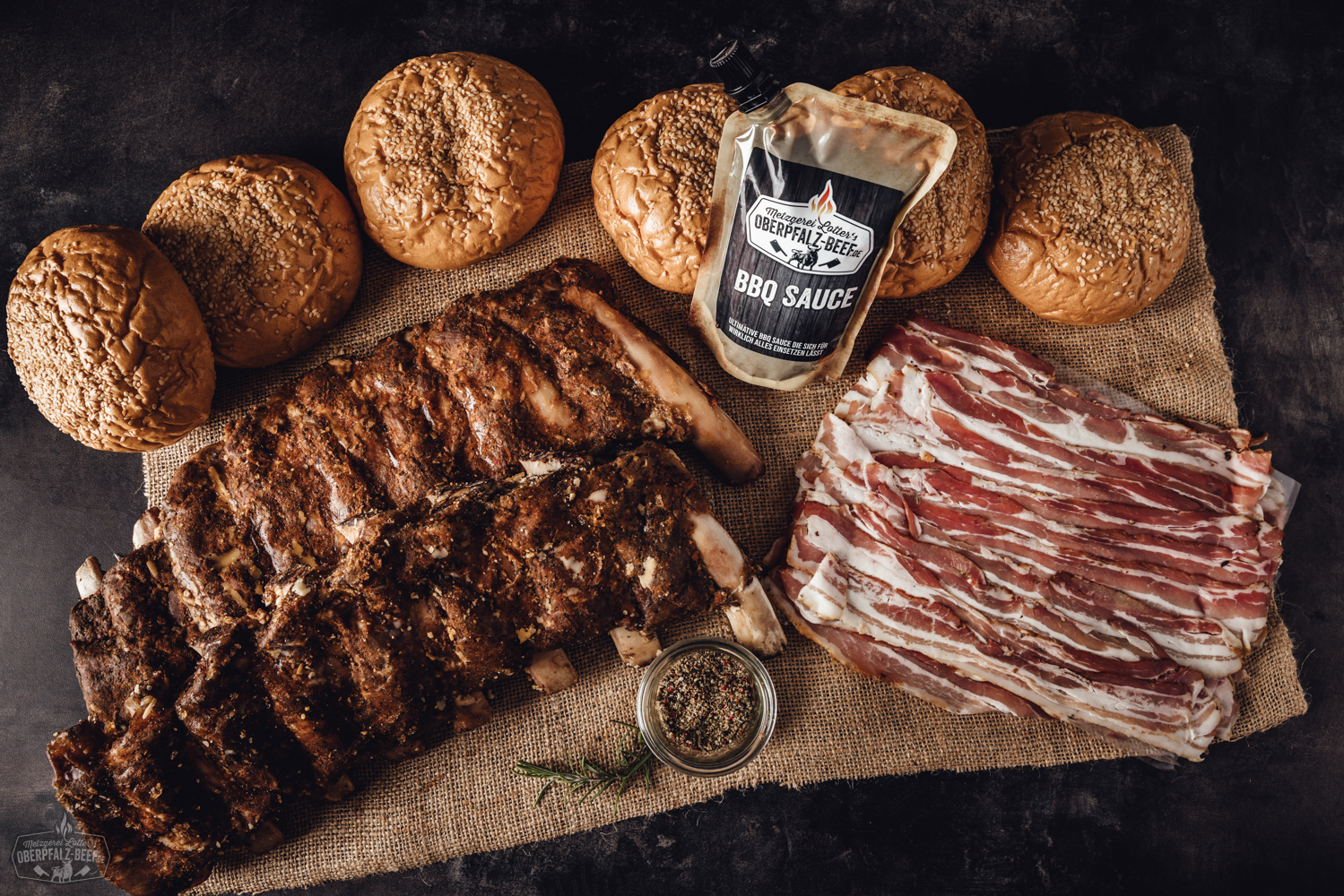 Sous-vide gegarte Beef Back Ribs vom Oberpfalz-Rind in praktischer Box – zart & saftig Sous-vide gegarte Beef Back Ribs vom Oberpfalz-Rind, saftig und goldbraun glasiert, angerichtet auf einem dunklen Holzbrett mit Rosmarinzweig und Gewürzen – perfekte Zubereitung für Grill- oder BBQ-Fans.