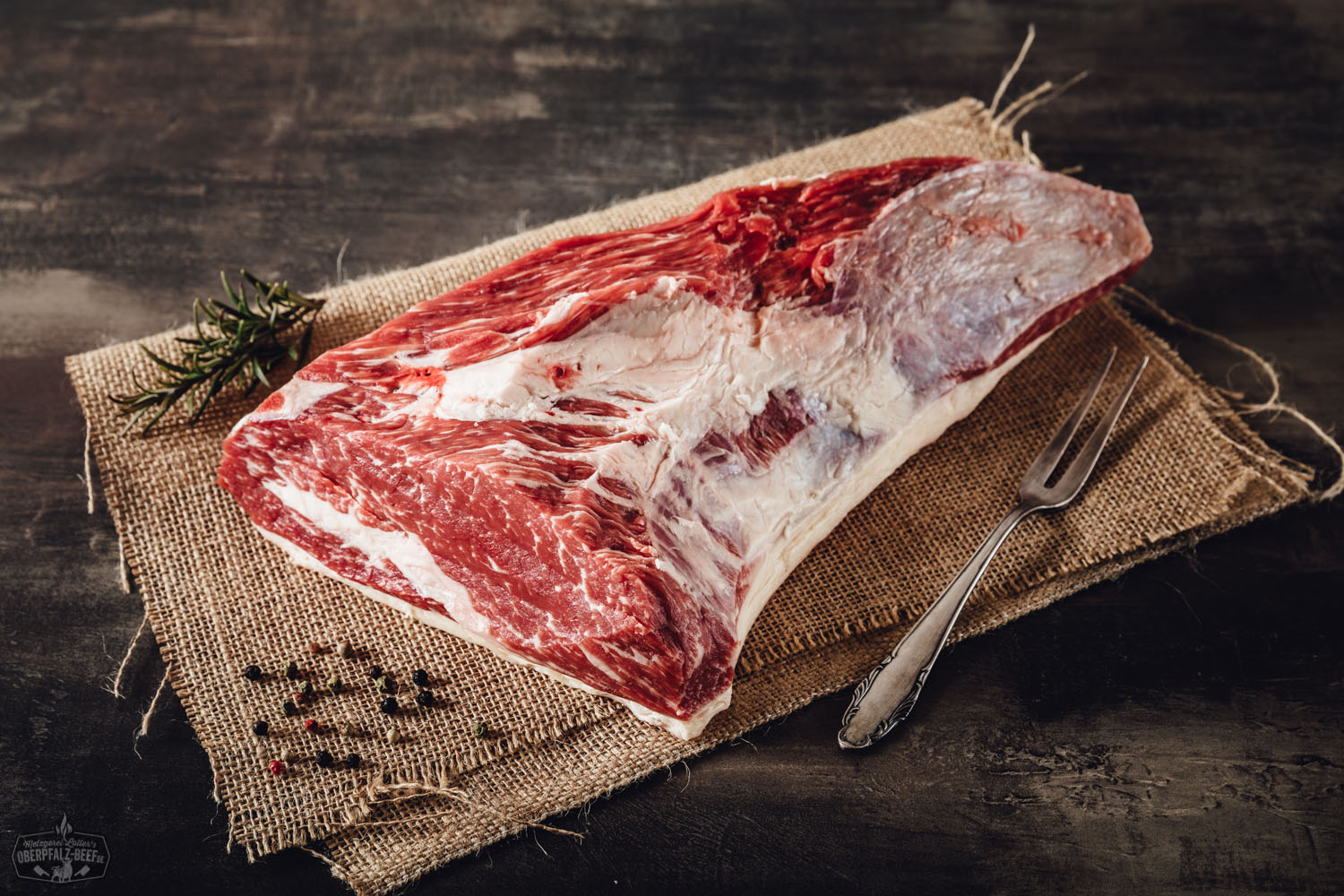 Rohes Tri-Tip-Steak vom Oberpfalz-Rind, wet-aged gereift, auf schwarzem Untergrund präsentiert – gut marmoriertes Rindfleischstück mit sichtbarer Fettstruktur, ideal zum Grillen oder Braten.