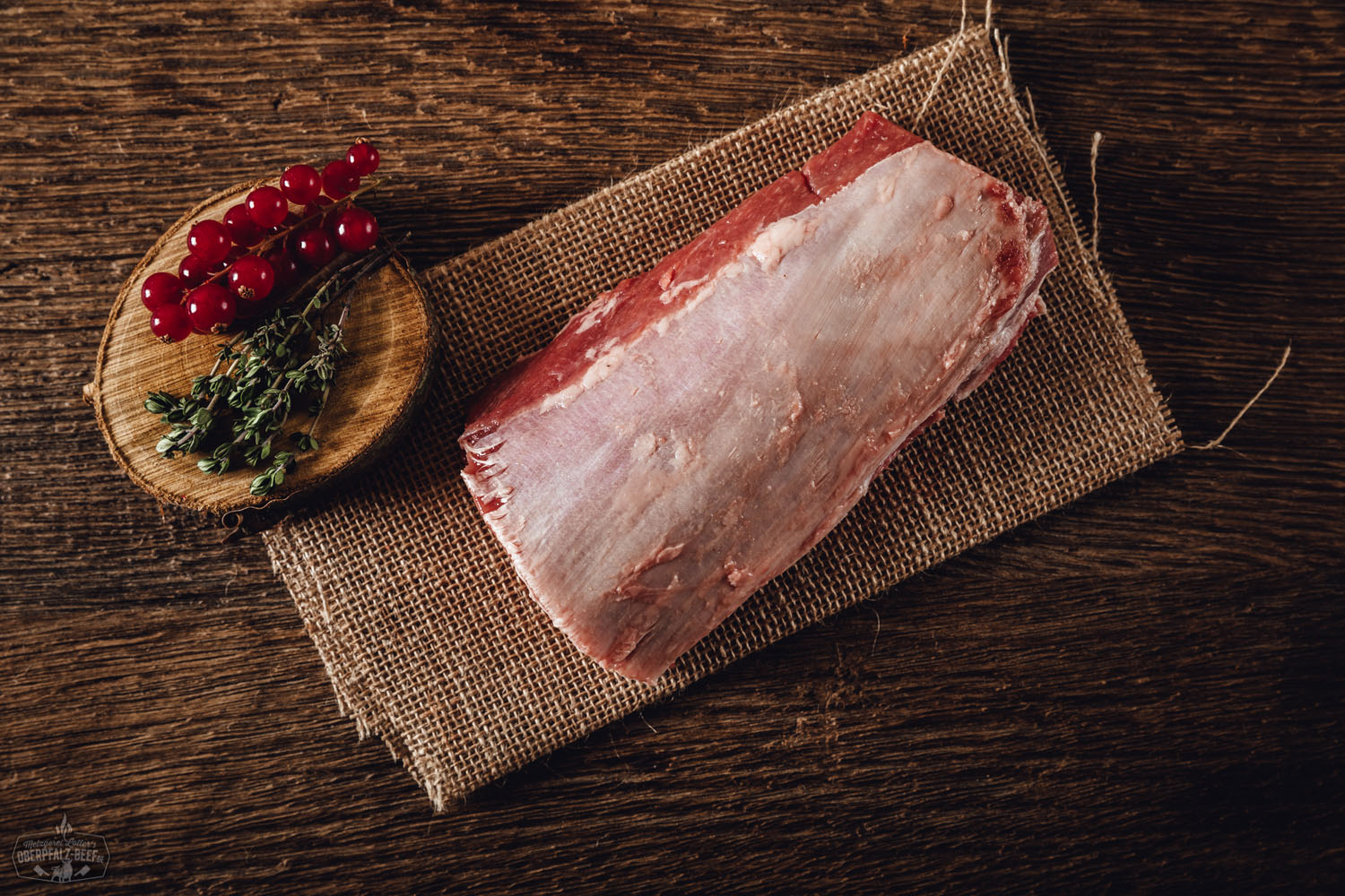Rücken ohne Knochen vom Oberpfälzer Wildschwein – Frisches Wildfleisch regionaler Herkunft Frischer, roher Wildschweinrücken ohne Knochen aus der Oberpfalz, auf schwarzem Untergrund angerichtet, mit sichtbarer Marmorierung und frischem Rosmarinzweig garniert – hochwertiges Wildfleisch für Wildschwein-Rezepte und Fleischliebhaber.