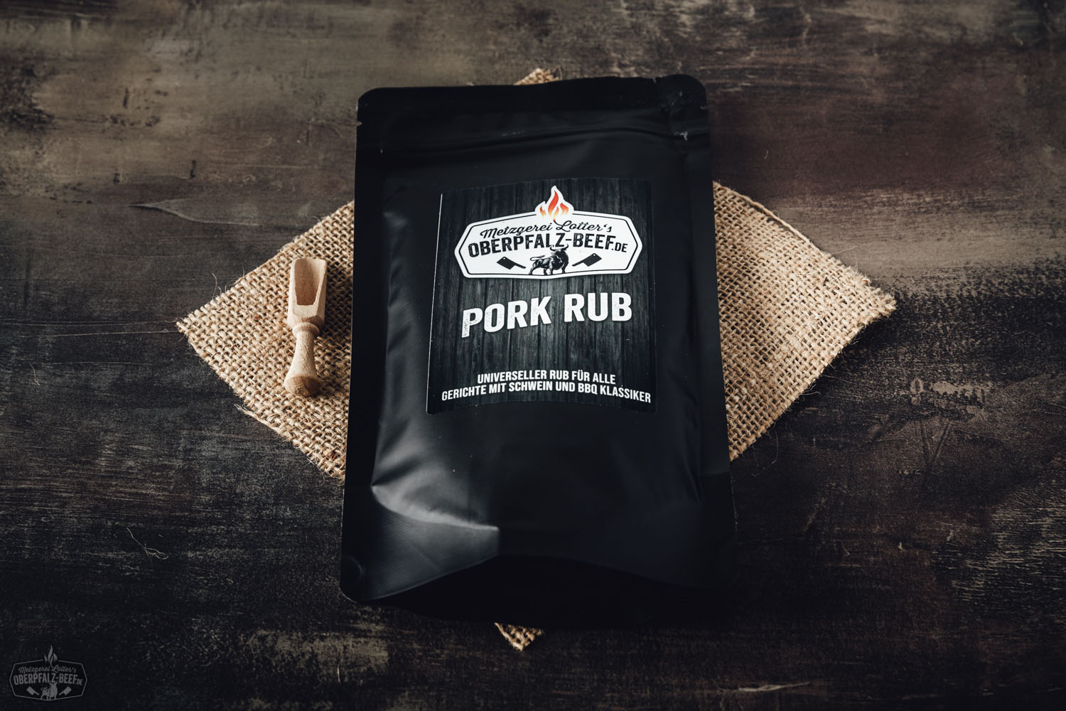 Gewürzmischung "Pork Rub" von Oberpfalz Beef in schwarzer Gewürzdose mit Rillenstruktur, rote Etikettenaufschrift, platziert auf dunklem Untergrund mit verstreuten Gewürzen – ideal für BBQ und Fleischgerichte.