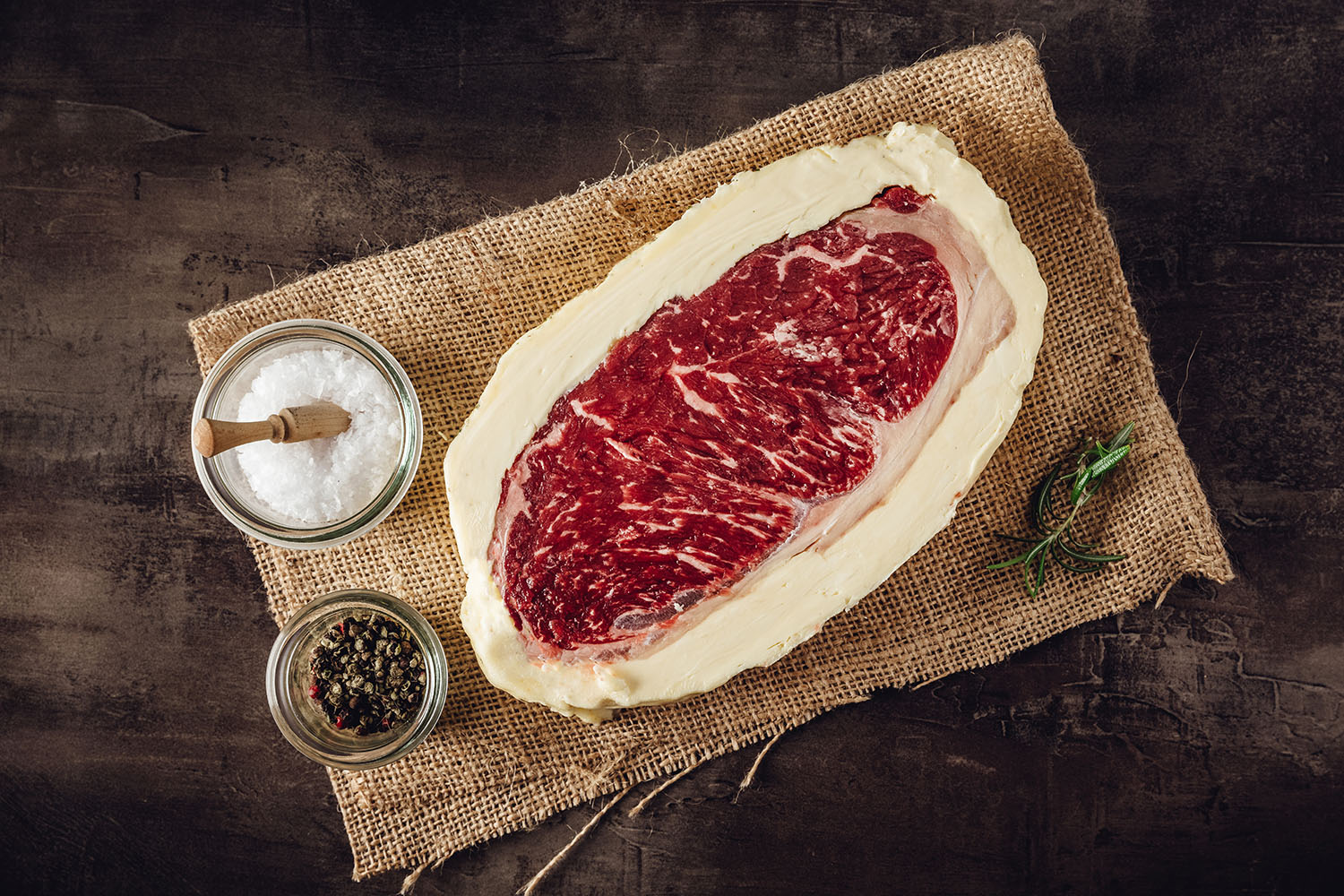 Roastbeef Steak mit Kräuterbutter vom Oberpfalz-Rind – Dry Aged Fleisch in Premium-Qualität Roastbeef-Steak vom Oberpfalz-Rind, medium gebraten, mit sichtbarer Marmorierung und goldbrauner Kruste, serviert mit einem Stück Butter und Kräutergarnitur auf Holzbrett – hochwertige Dry-Aged Fleischspezialität.
