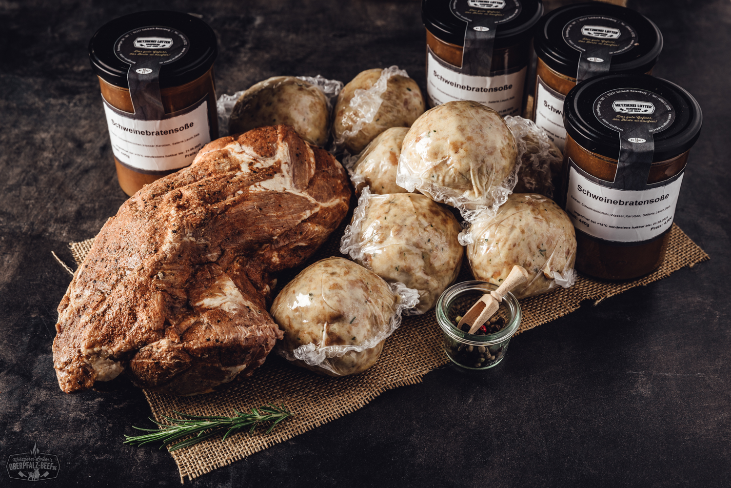 Sous-vide gegarter Oberpfälzer Kalbsrollbraten in geöffneter Gourmet-Box, vakuumverpackt mit frischen Kräutern, auf Holztisch präsentiert – hochwertiges, fertig zubereitetes Fleischprodukt für Feinschmecker.