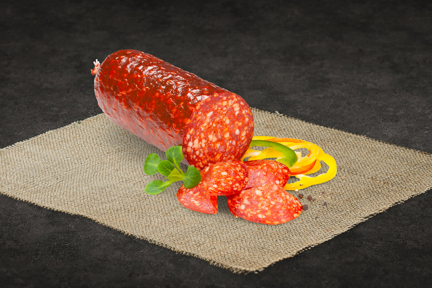 Chorizo Salami geschnitten – luftgetrocknete Spezialität aus der Oberpfalz Geschnittene luftgetrocknete Siliana-Salami auf einem Holzbrett angerichtet, mit Kräutern und Pfeffer garniert – hochwertige Delikatesswurst aus der Oberpfalz, ideal für Brotzeit oder Feinkostplatte.