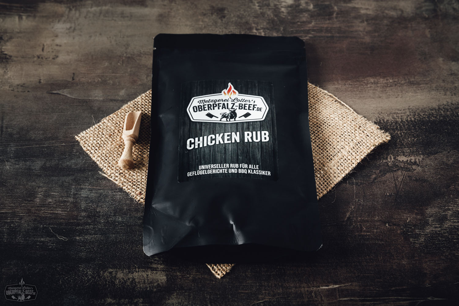 Gewürzmischung "Chicken Rub" von Oberpfalz Beef in schwarzer Dose mit rotem Etikett, dekorativ platziert neben Grillgewürzen und Kräutern auf dunklem Untergrund – perfekt zum Würzen von Geflügel beim BBQ oder Grillen.