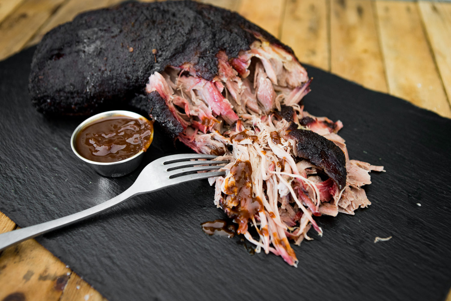 Schweinehals ohne Knochen für Pulled Pork – saftiges Fleisch ideal zum Slow Cooking Roher Schweinehals ohne Knochen auf schwarzem Untergrund, gut marmoriert mit sichtbarer Fettstruktur – ideales Stück Fleisch für Pulled Pork Zubereitung.