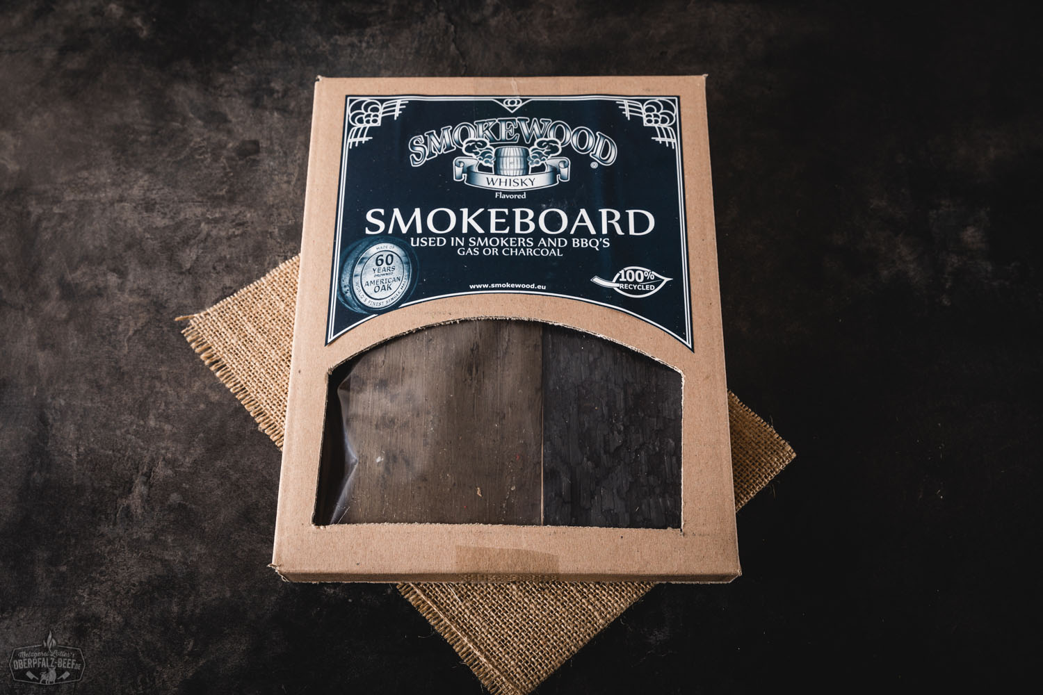 Räucherholz-Board aus massivem Holz mit "Smokewood Whiskey"-Gravur, naturbelassen auf rustikaler Holzfläche platziert – ideal zum Aromatisieren von Grillgut mit feinem Whiskyaroma.