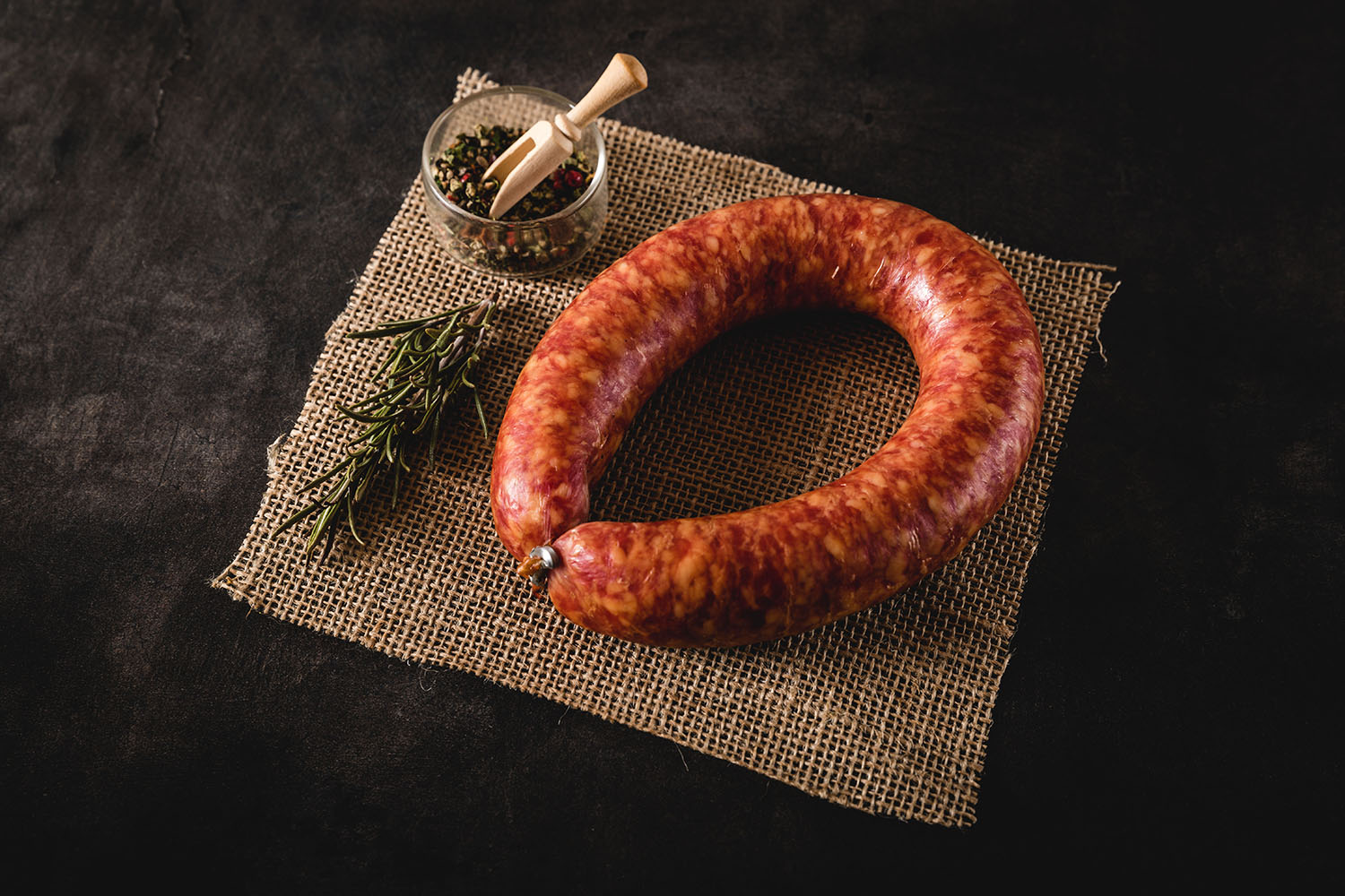 Geräucherte Oberpfälzer Bauernbratwurst im Ring – Traditionelle Delikatesse aus Bayern Geräucherte Oberpfälzer Bauernbratwurst im Ring auf Holzbrett angerichtet, dunkelbraune, glänzende Oberfläche mit natürlicher Krümmung, im Hintergrund traditionelle Dekoration und Brot – typisch bayerische Spezialität.