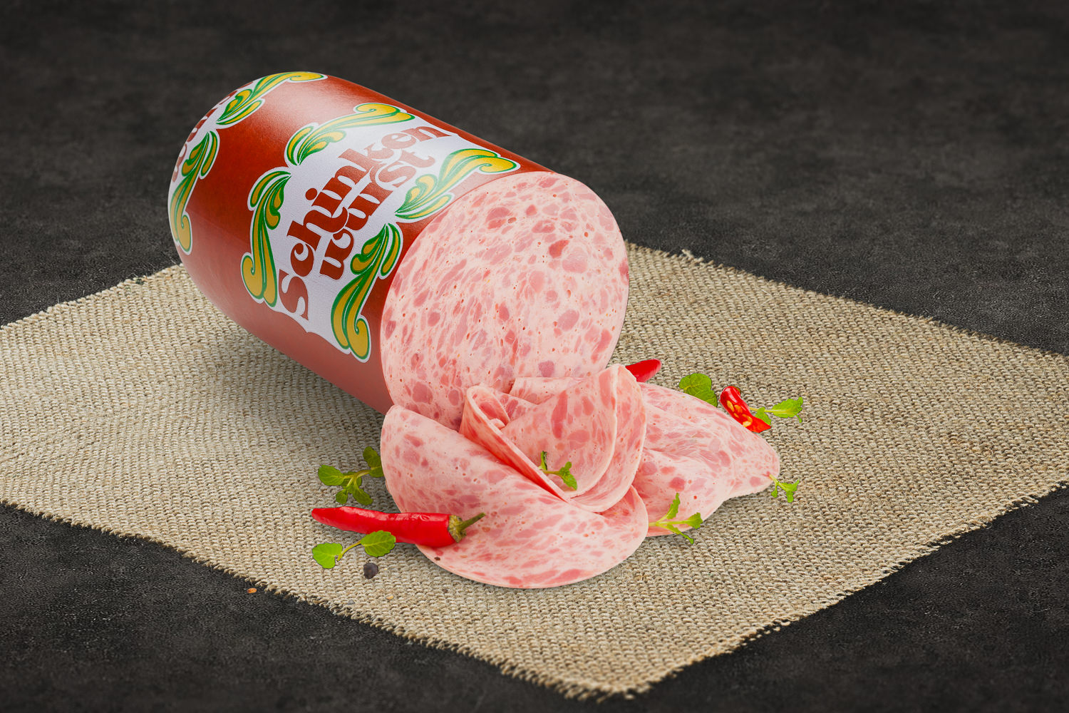 Geschnittene grobe Schinkenwurst auf Holzbrett angerichtet, mit Petersilie garniert – deftige Wurst aus der Oberpfalz in rustikaler Präsentation.
