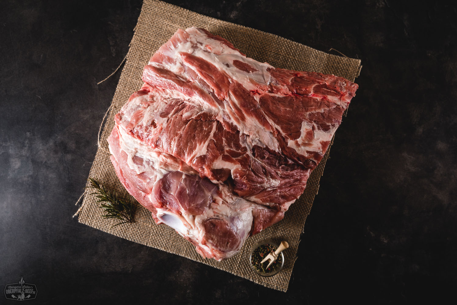 Boston Butt vom Oberpfälzer Landschwein – hochwertiges Schweinefleisch für BBQ und Slow Cooking Rohes Boston Butt Fleischstück vom Oberpfälzer Landschwein, marmoriert mit Fettanteilen, auf dunklem Untergrund dekorativ präsentiert – hochwertiges Schweinefleisch für BBQ oder Pulled Pork.