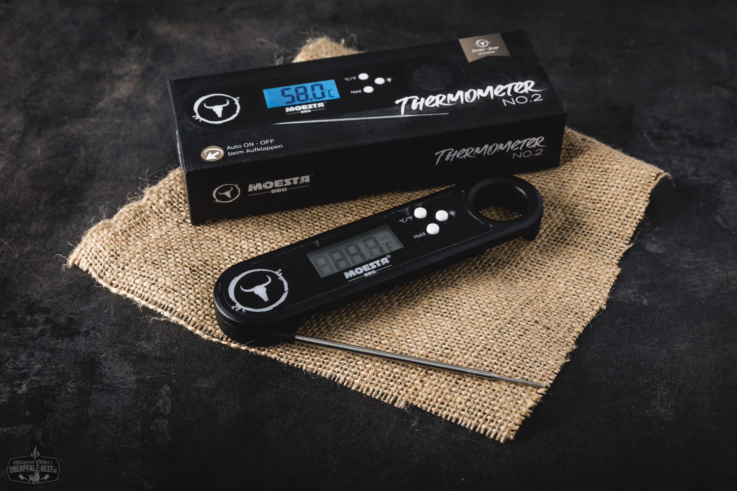 Digitales Grill- und Bratenthermometer Moesta BBQ No. 2 in Nahaufnahme – Gerät mit zwei Messfühlern, gut lesbarem LCD-Display, Edelstahl-Sonden und schwarz-silbernem Design auf weißem Hintergrund.