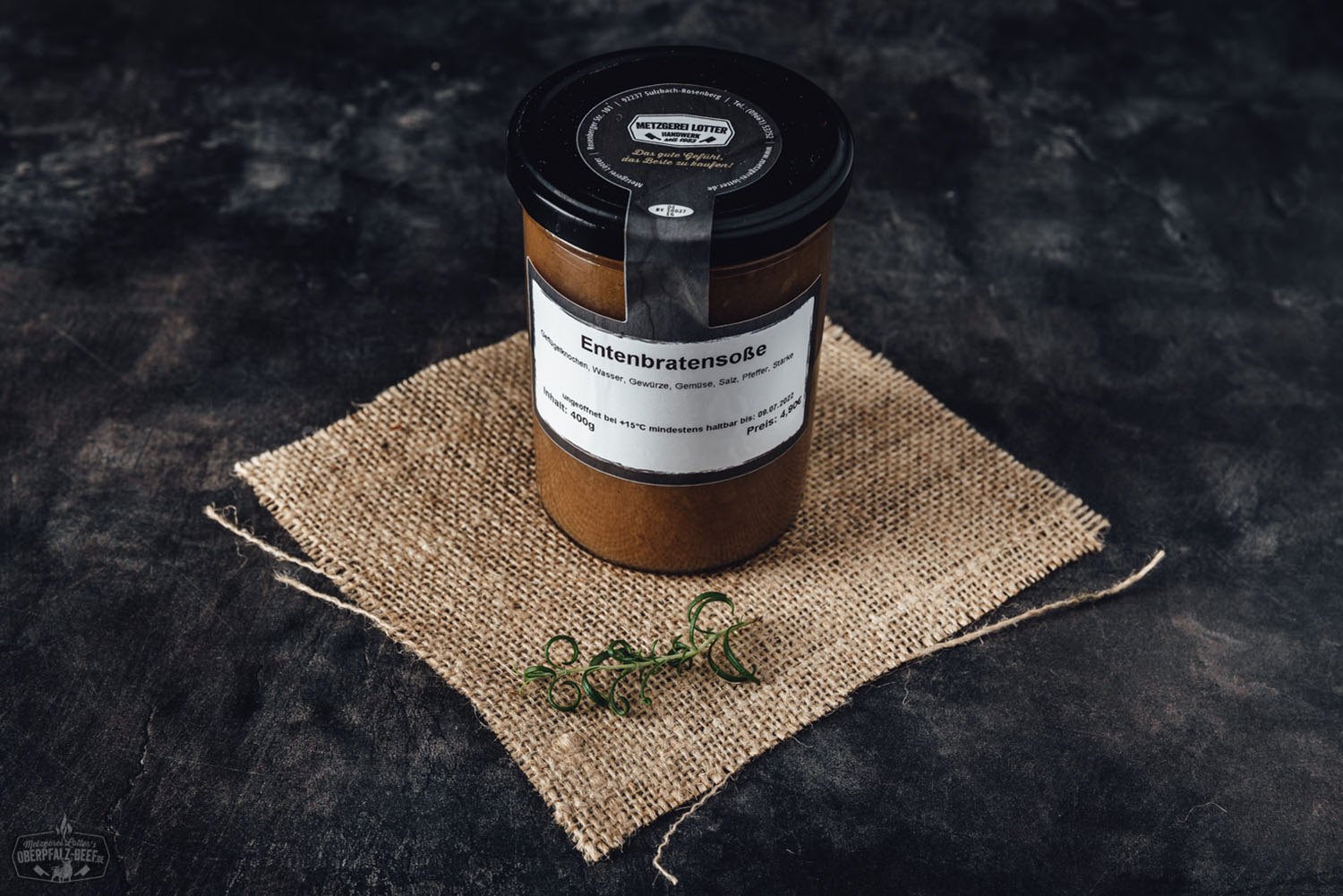 Entenbratensoße im Glas – Hausgemachte Bratensoße für Geflügelgerichte Ein Schraubglas mit dunkelbrauner Entenbratensauce von Oberpfalz Beef, beschriftet mit Etikett „Entenbratensosse“, vor hellem Hintergrund auf Holzuntergrund – traditionelle Feinkost als fertige Sauce im Glas.