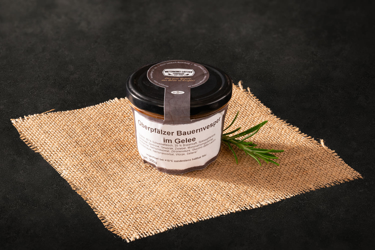 Bauernvesper mit Wurst, Eiern und Gurkenstücken in klarer Aspik-Gelee auf weißem Teller, rustikal angerichtet mit Petersiliengarnitur – traditionelle bayerische Hausmannskost.