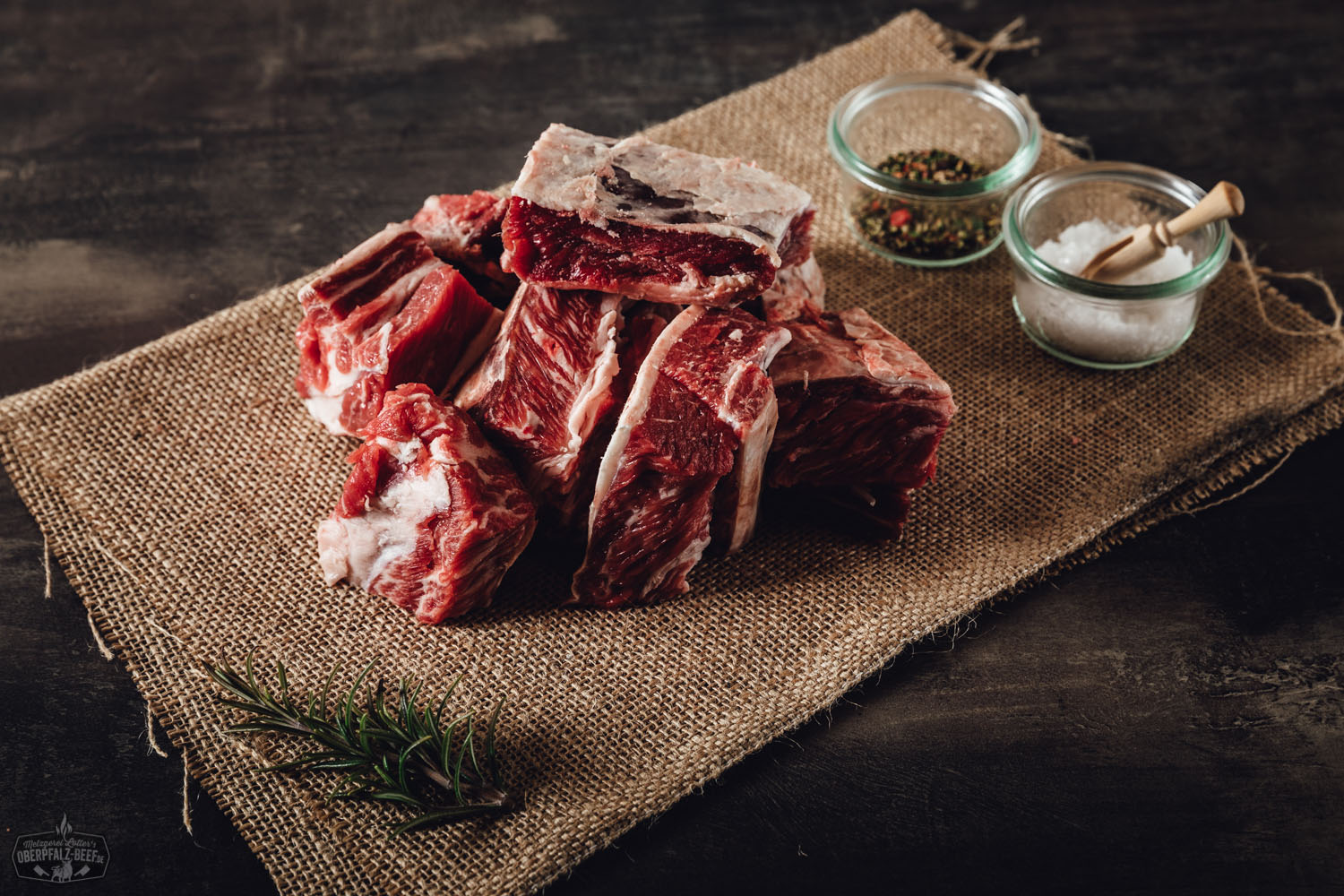Dry Aged Burgerpatties vom Oberpfalz-Rind – Premium Rindfleisch für echten Genuss Fleisch für Dry Aged Burgerpatties vom Oberpfalz Rind, hochwertige Rindfleischstücke auf einem Holzbrett präsentiert, geeignet für Gourmet-Burgerliebhaber, frisches und regionales Produkt.