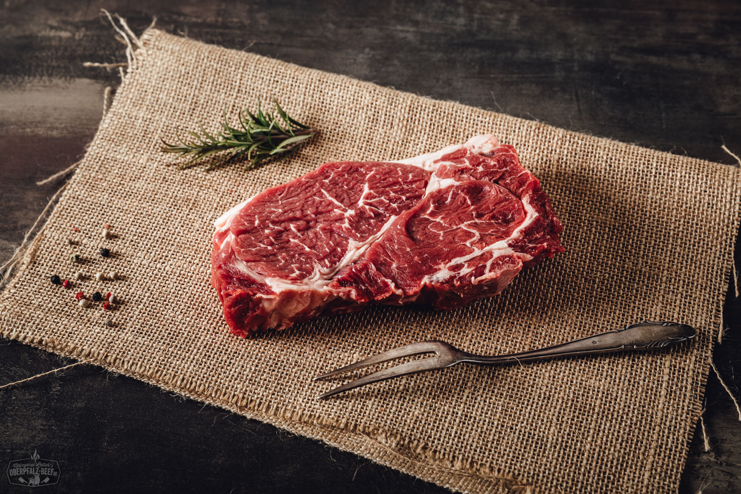 Rohes Chuck Roll Steak vom Oberpfalz-Rind, saftig-marmoriert und vakuumverpackt auf dunklem Untergrund präsentiert – hochwertiges Fleisch, wet-aged gereift, ideal zum Grillen oder Braten.