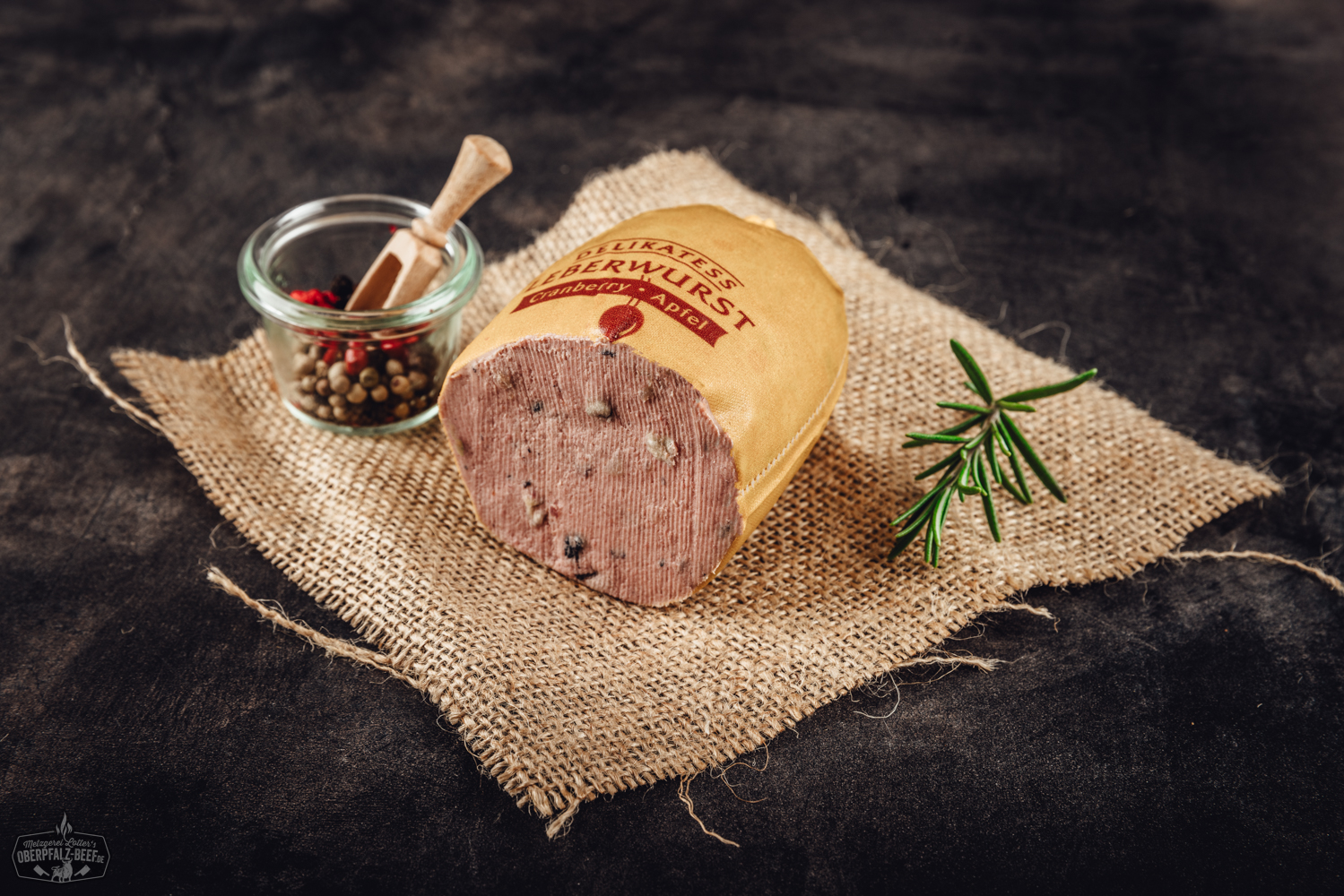 Kalbfleischleberwurst mit Cranberry und Apfel – Feine Delikatesse im Glas Glas mit Trüffel-Kalbsleberwurst auf dunklem Untergrund, daneben frische Trüffelscheiben und Gewürze dekorativ angerichtet – Gourmet-Delikatesse aus der Oberpfalz.