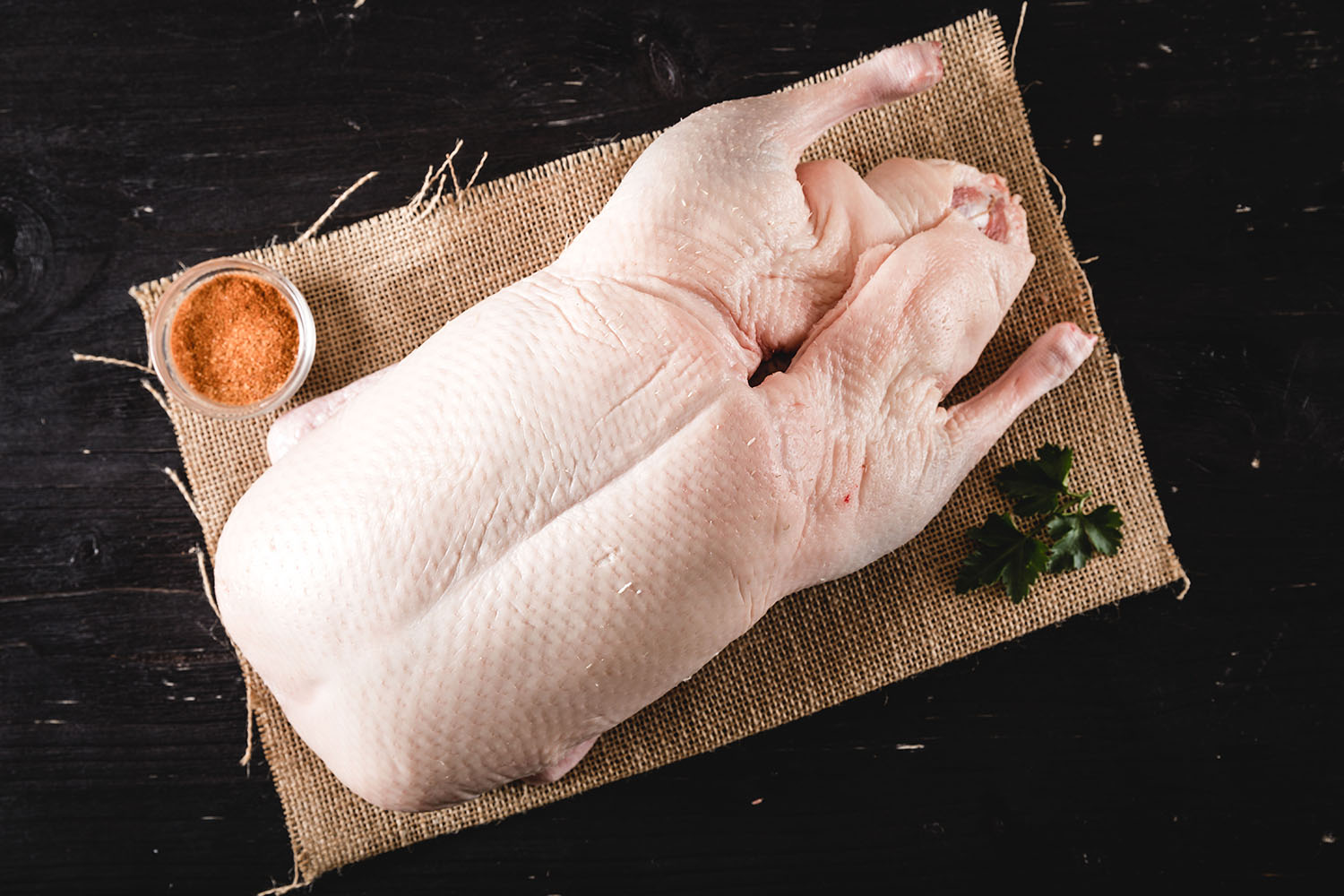Oberpfälzer Bauernente in hochwertiger Fleischqualität, roh und portioniert auf einem Holzbrett präsentiert, ideal für regionalen Genuss und traditionellen Entenbraten.