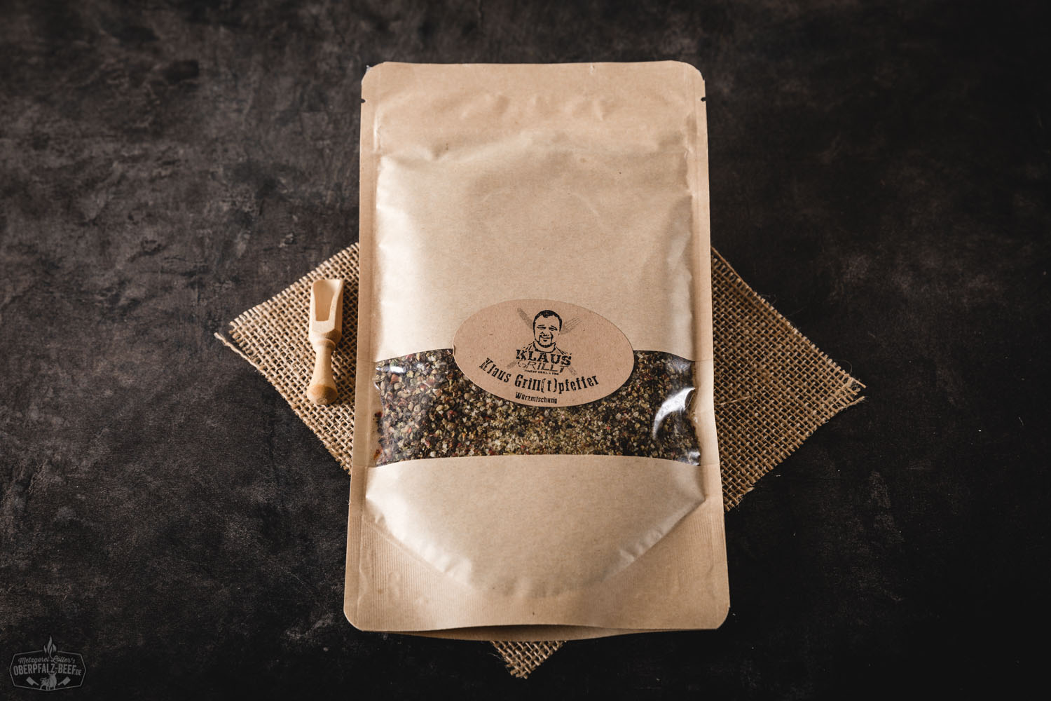 Pfeffer-Mix im Aromabeutel von Klaus grillt – Gewürzmischung für perfektes BBQ Klaus grillt Pfeffer im Beutel auf einem Grill - Nahaufnahme mit gewürzten Fleischstücken auf dem Rost, aromatisches Grillen im Freien.