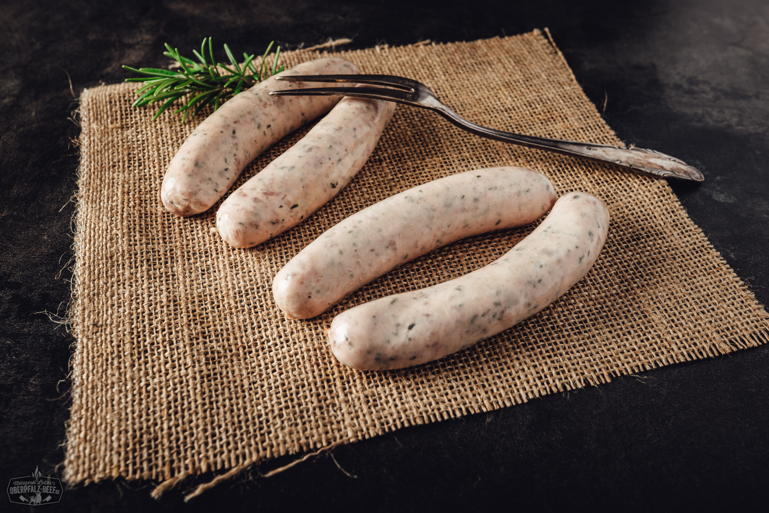 Bärlauchbratwürste frisch gegrillt auf Holzbrett – regionale Delikatesse aus der Oberpfalz Drei gebratene Bärlauchbratwürste liegen auf einem Holzbrett, angerichtet mit frischem Bärlauch, grobem Salz und Pfefferkörnern – Nahaufnahme unter natürlichem Licht, typisch für regionale Oberpfälzer Spezialitäten.