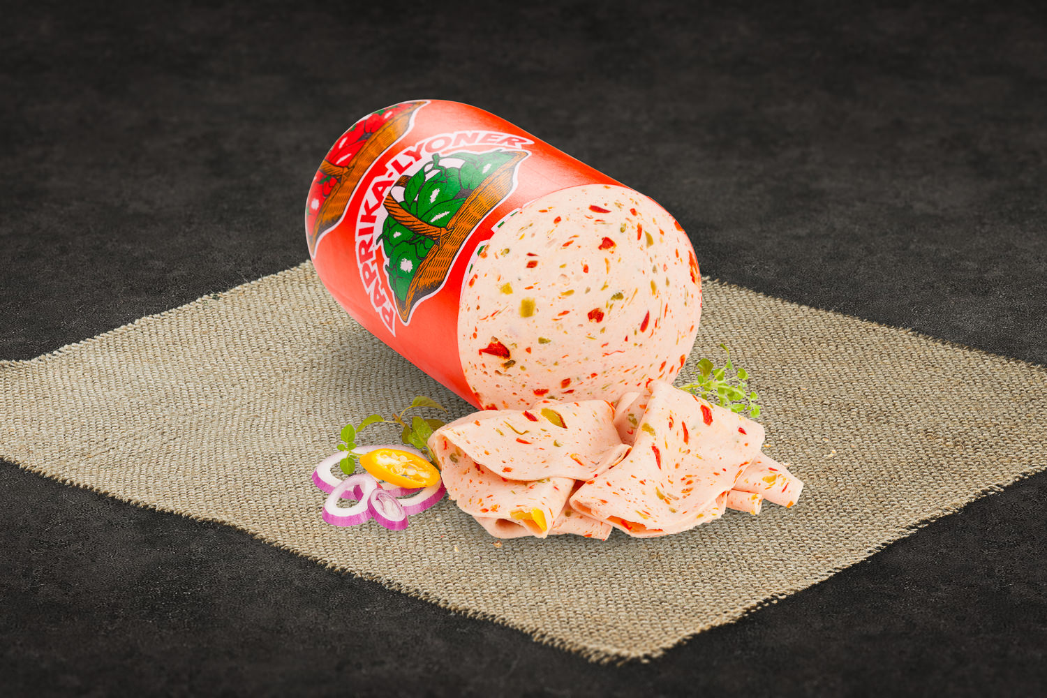 Ein aufgeschnittener Presssack aus regionaler Herstellung liegt auf einem Holzbrett, umgeben von Zwiebelringen, frischer Petersilie und Brot – traditionell bayerische Brotzeit mit hausgemachter Wurst aus der Oberpfalz.