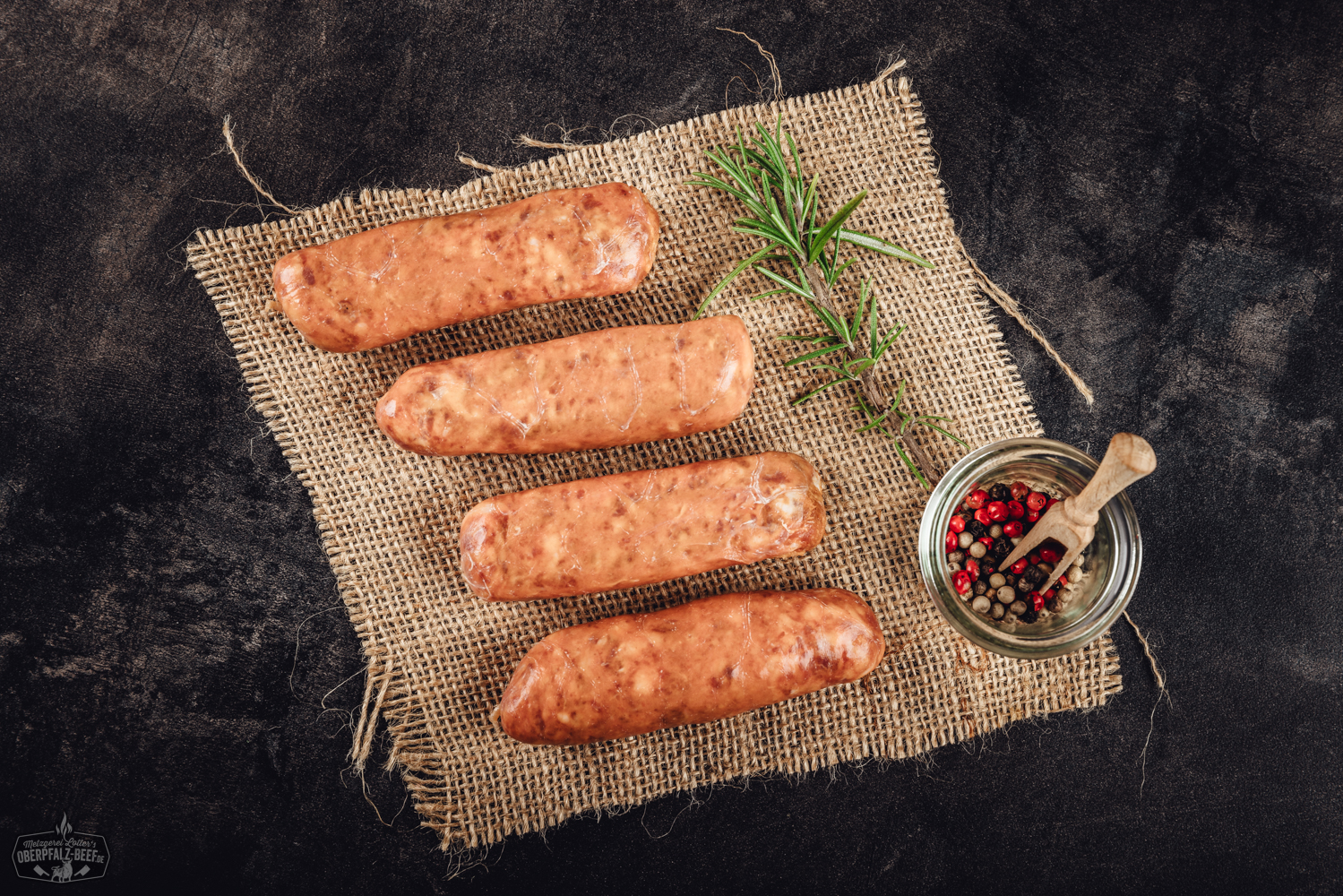 Gegrillte Chorizo-Bratwürste auf Holzbrett mit frischen Kräutern Nahaufnahme von sechs gegrillten Chorizo-Bratwürsten auf einem Grillrost, goldbraun gebräunt mit leichter Röstaroma, im Hintergrund glimmende Holzkohle; rustikales Grillambiente, deutlicher Fokus auf würzige Bratwürste aus regionaler Herstellung.