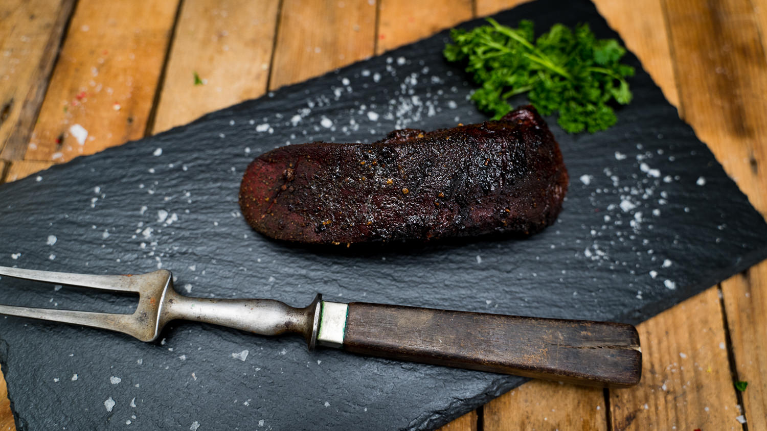 Frische rohe Schweinezunge auf weißem Hintergrund – hochwertiges Fleischprodukt Frisch gegarte Schweinezunge auf Holzbrett angerichtet, im Anschnitt sichtbar zart und saftig, mit Petersiliengarnitur – traditionelle Delikatesse aus der Oberpfalz.