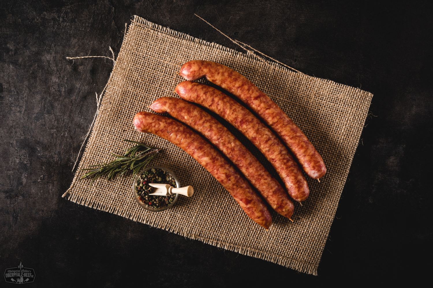 Pfefferbeißer Würstchen aus der Oberpfalz – herzhaft geräuchert und regional gefertigt Aromatische Pfefferbeißer Wurst aus Oberpfalz Beef auf einem rustikalen Holztisch platziert, perfekt zur Brotzeit und für Liebhaber würziger Fleischspezialitäten.