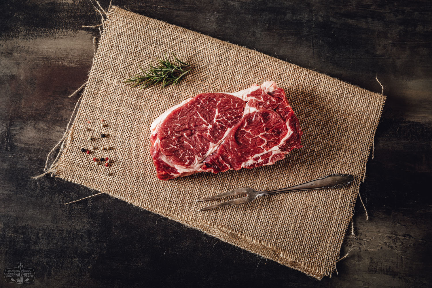 Chuck Roll Steak – zart gereiftes Wet Aged Rindfleisch vom Oberpfalz-Rind Rohes Chuck Roll Steak vom Oberpfalz-Rind auf dunklem Untergrund, fettmarmoriert und vakuumverpackt präsentiert – hochwertiges Rindfleisch, ideal zum Wet Aging und Grillen.