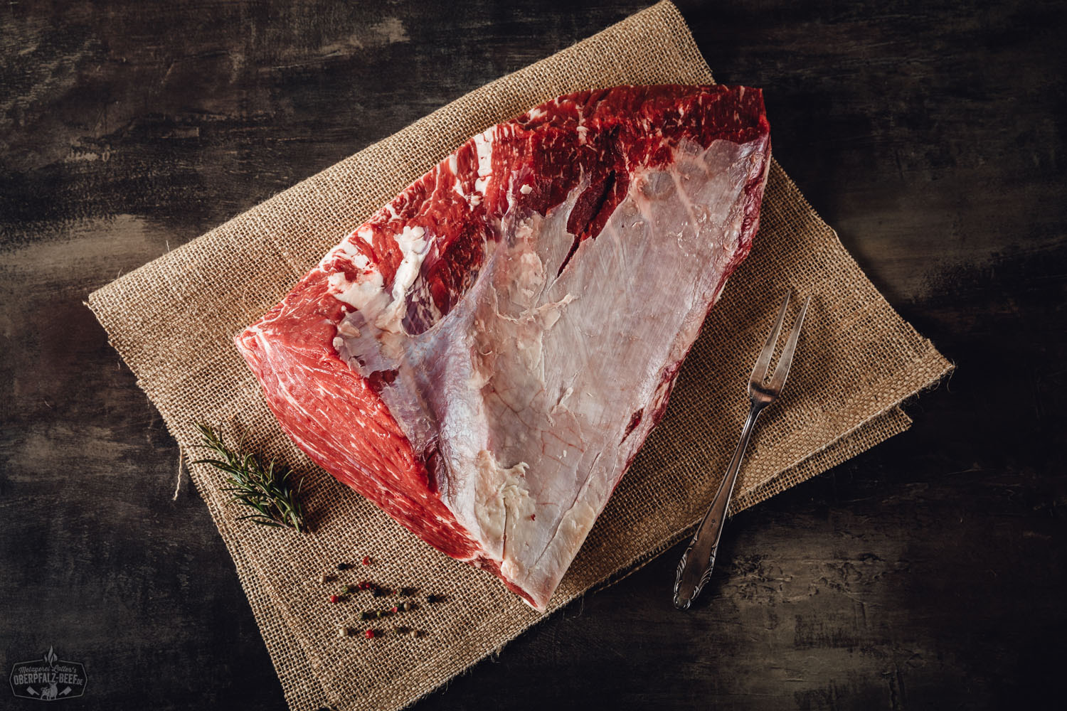Rinderbraten aus der Tafelspitz vom Oberpfalz-Rind auf rustikalem Holzbrett angerichtet Rinderbraten aus der Schwanzrolle vom Oberpfalz-Rind aufgeschnitten auf Holzbrett, saftig und medium gegart, mit kräftiger Bräunung und sichtbarer Fleischstruktur, serviert mit Rosmarinzweig und Bratensaft – traditionelles Rindfleischgericht aus Bayern.