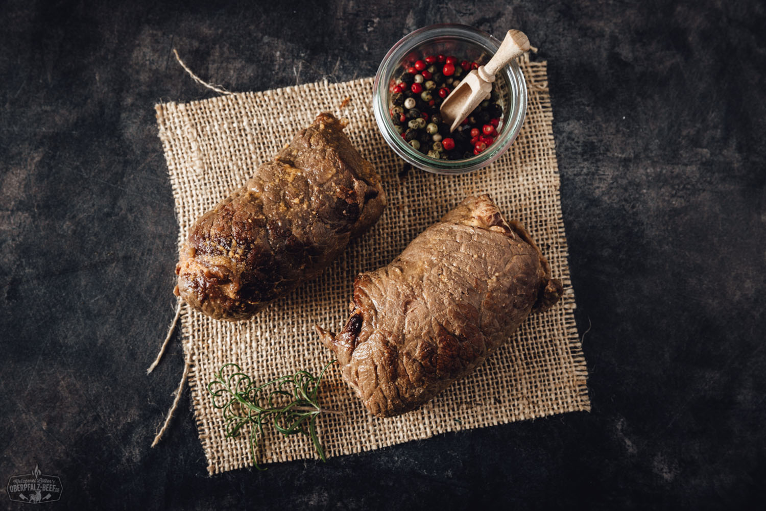 Sous-vide gegarte Rinderroulade vom Oberpfalz-Rind – zart, saftig & regional Angeschnittene, sous-vide gegarte Rinderroulade vom Oberpfalz-Rind auf dunklem Teller angerichtet, gefüllt mit Speck, Gurke und Zwiebel, daneben Soße und Kräuter-Deko; hochwertige Fleischspezialität in Gourmet-Präsentation.