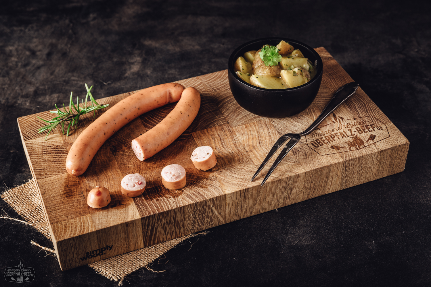 Pizzawiener mit geschmolzenem Käse und Tomatenfüllung auf Holzbrett Vier gebräunte, goldbraun gebratene Pizzawiener mit sichtbaren Käse- und Paprikastückchen liegen auf einem rustikalen Holzbrett, daneben frische Kräuter und eine aufgeschnittene Tomate – deftige Grillwurst-Spezialität mit mediterraner Note.