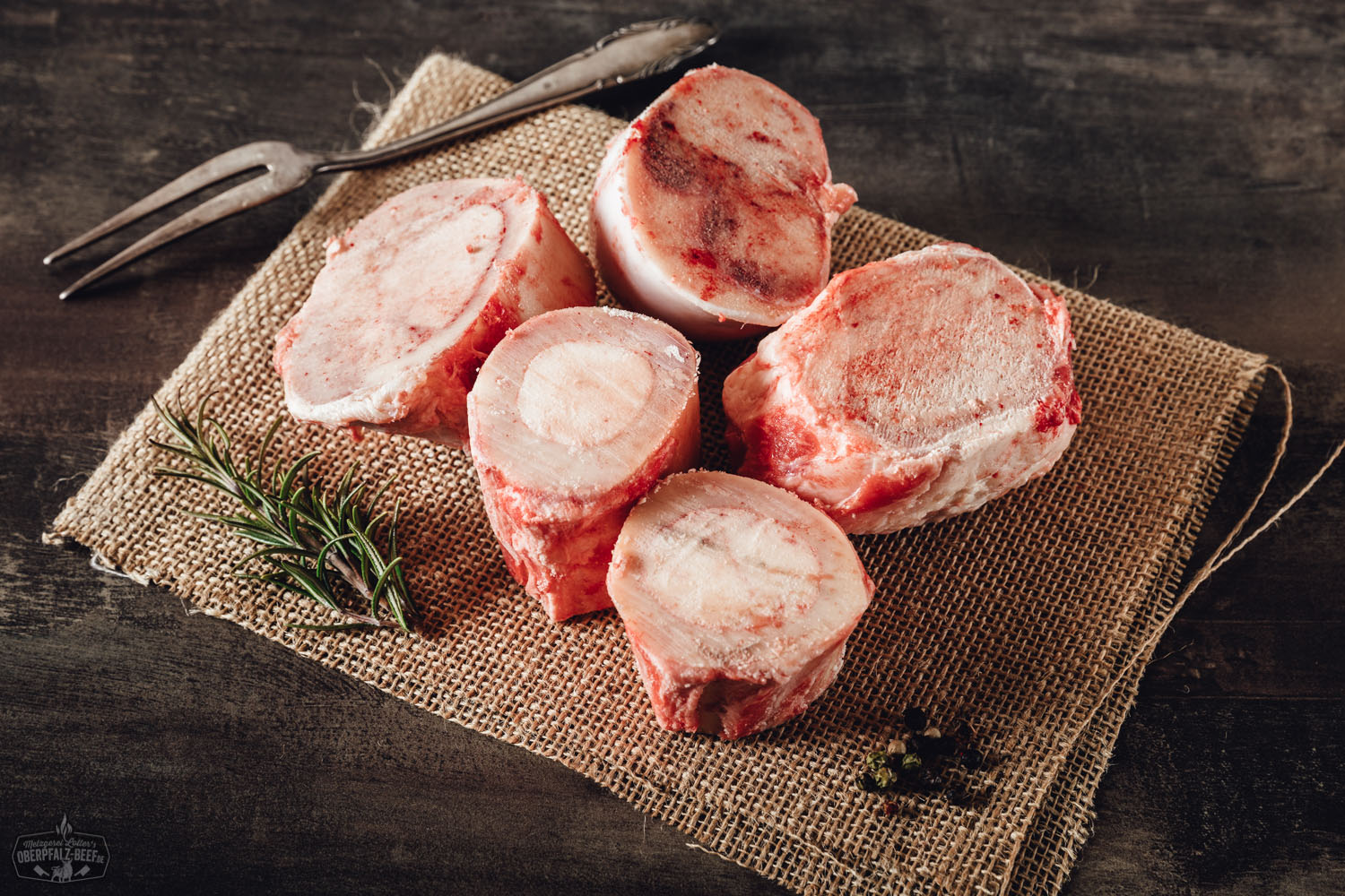 Suppenknochen mit Mark vom Oberpfalz-Rind – Regionales Rindfleisch für kräftige Brühen Suppenknochen mit Mark vom Oberpfalz-Rind roh auf dunklem Untergrund arrangiert; gut sichtbare Schnittflächen mit Markfüllung, naturbelassen, zur Herstellung von Brühe oder Fonds – hochwertiges Rindfleischprodukt aus regionaler Zucht.