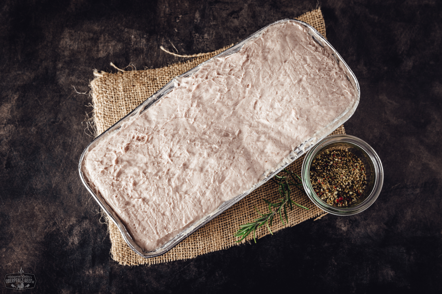 Oberpfälzer Leberkäse zum Selberaufbacken – traditioneller Fleischkäse aus Bayern Aufgeschnittener Oberpfälzer Leberkäse in goldbrauner Kruste auf weißem Teller mit Senf, angerichtet auf Holztisch – traditionelle bayerische Spezialität zum Selberaufbacken.