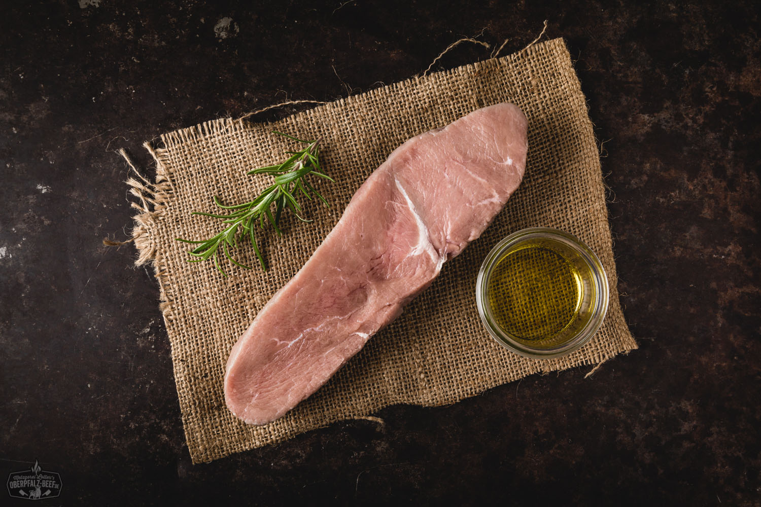 Zartes Kalbs-Hüftsteak – Premium Fleischqualität aus der Oberpfalz Huftsteak vom Kalb, medium gebraten, auf einem dunklen Servierbrett angerichtet, mit grobem Meersalz und frischen Rosmarinzweigen garniert, im warmen Licht präsentiert – hochwertiges Kalbfleisch als edles Steakgericht.