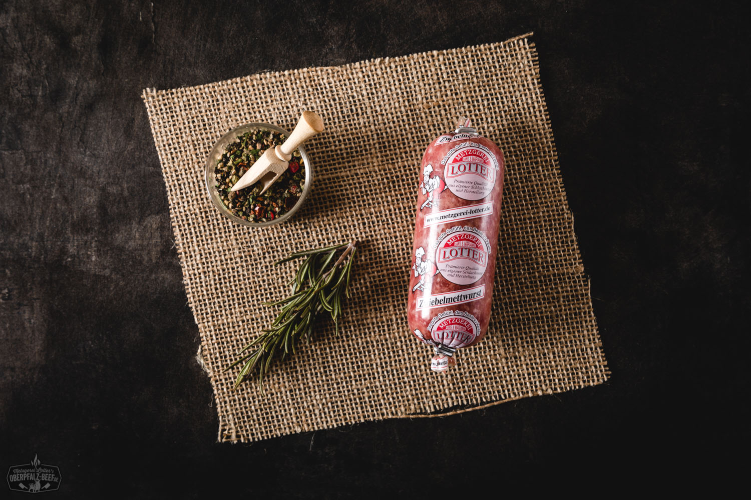 Zwiebelmettwurst Mini – Herzhafte Rohwurst mit Zwiebeln Zwischenprodukt: Mini Zwiebelmettwurst, appetitlich angerichtet auf einem hellen Hintergrund, mit sichtbarer Fleischstruktur und handlicher Größe, ideal für einen herzhaften Snack oder Brotbelag.