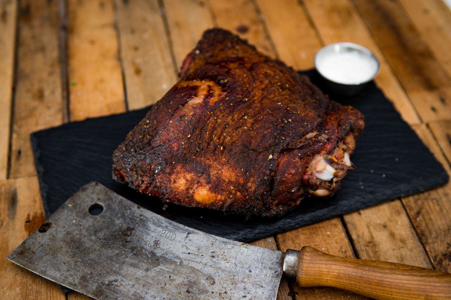 Frische Putenoberkeule roh – hochwertiges Geflügelfleisch für gesundes Kochen Rohe Putenoberkeule auf Holzbrett, von frischem grünen Rosmarin, Knoblauchzehen und buntem Pfeffer umgeben, ideal für Braten oder Schmoren, hochwertiges Geflügelfleisch für gesundes Kochen.