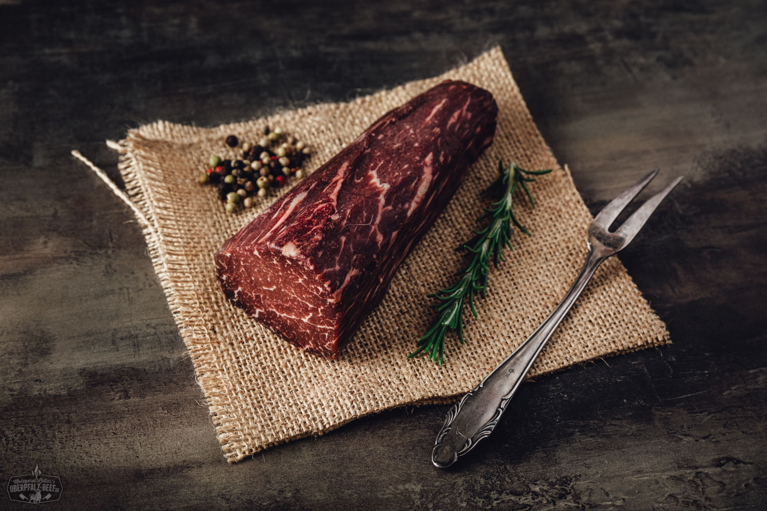 Nahaufnahme von zart angebratenen Dry Aged Filetspitzen vom Oberpfalz-Rind auf dunklem Untergrund, angerichtet mit frischen Kräutern und grobem Meersalz, hochwertiges Rindfleisch in Premium-Qualität, Gourmetgericht aus regionaler Fleischmanufaktur.