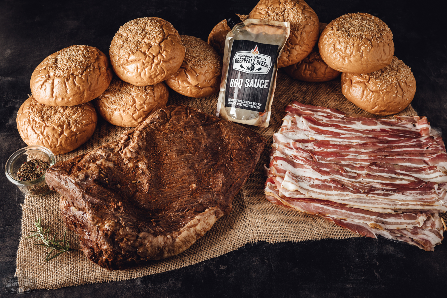 Sous-vide Beef Brisket Box vom Oberpfalz-Rind – zartes Rinderbrustfleisch vorgegart Zart gegarte Beef Brisket Scheiben vom Oberpfalz-Rind, angerichtet auf einem dunklen Holzbrett mit Kräutergarnitur; im Hintergrund Verpackung der Sous-vide vorgegarten Beef Brisket Box – hochwertiges Rindfleisch-Produkt für BBQ und Feinschmecker.