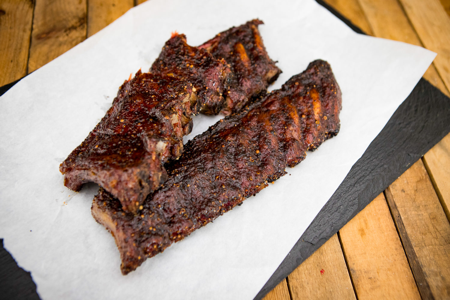 Tiefgefrorene Baby Back Ribs vom Schwein auf weißem Untergrund Tiefgefrorene Baby Back Ribs vom Schwein, roh und portionsweise vakuumverpackt, auf schwarzem Untergrund mit sichtbaren Eispartikeln – hochwertige Fleischqualität für BBQ und Grillgerichte.