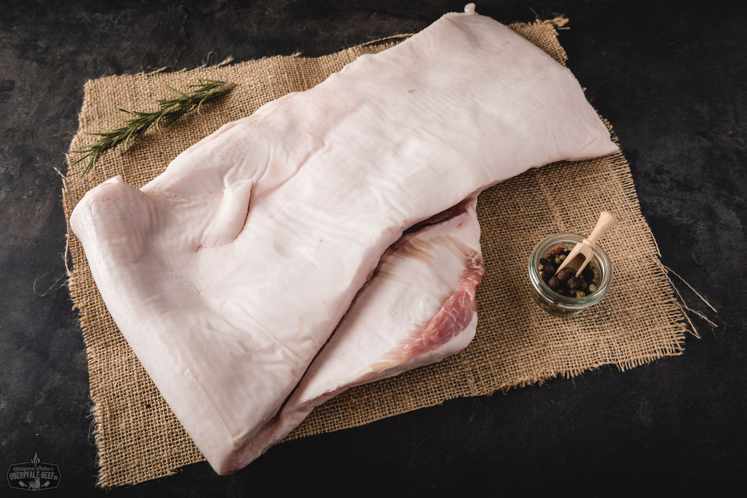 Frischer Speck vom Oberpfälzer Landschwein – regional, zart und aromatisch Frischer Speck vom Oberpfälzer Landschwein auf weißem Hintergrund mit Fett- und Fleischschichten sichtbar. Perfekt für kulinarische Zubereitungen und regionale bayerische Küche.
