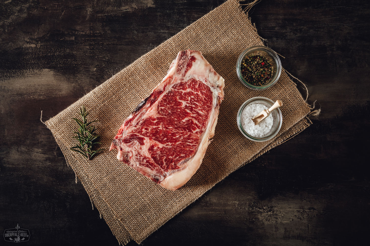 New York Cut Clubsteak Dry Aged von der alten Kuh – Premium Rindfleisch aus der Oberpfalz Dry Aged New York Cut Clubsteak von der alten Kuh roh auf Holzunterlage, marmoriertes Rindfleisch in Nahaufnahme mit sichtbarer Fettstruktur, hochwertiges Premium-Steak für Grill oder Pfanne.